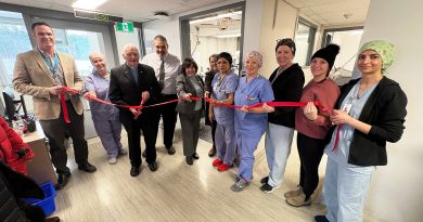 A group of people cut a ribbon.