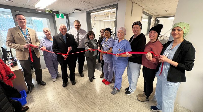 A group of people cut a ribbon.