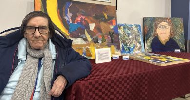 A woman poses with her artwork.
