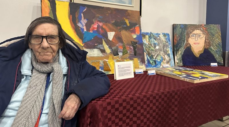 A woman poses with her artwork.