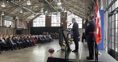 A person speaks to a room full of police.
