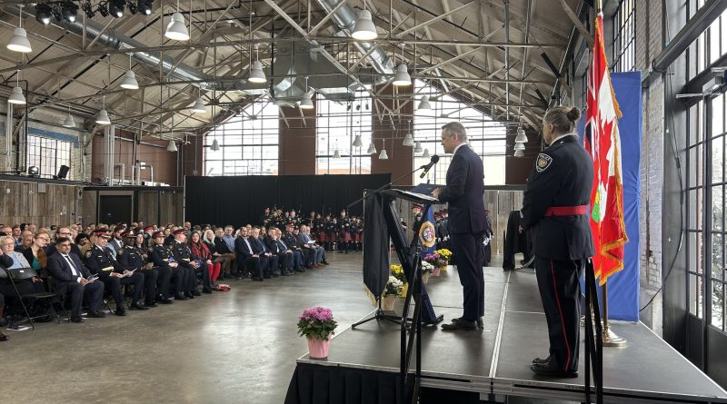 A person speaks to a room full of police.