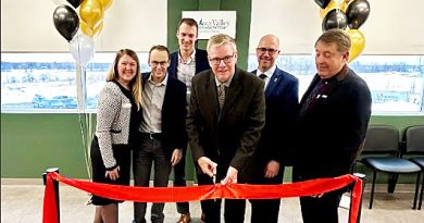 A group of people cut a ribbon.