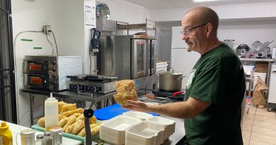 A man makes bread in a sandwich shop.