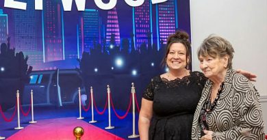 C Bay senior socials inspired by mom Two people pose in front of a Hollywood sign.