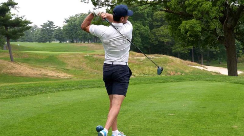 A photo of a golfer swinging.