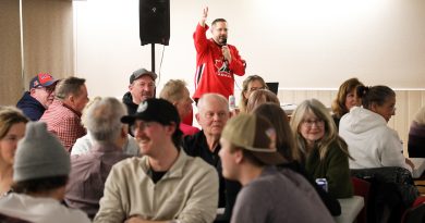 A man speaks to a full room.