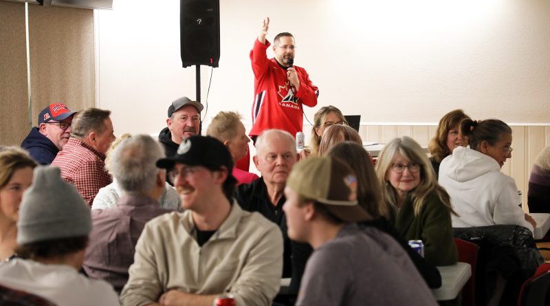 A man speaks to a full room.
