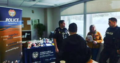 A group of police speak with a reporter.