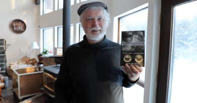 A photo of a man holding a book.