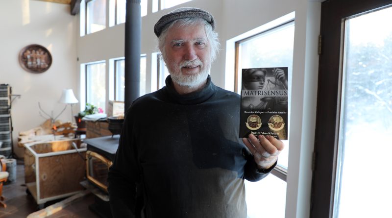 A photo of a man holding a book.