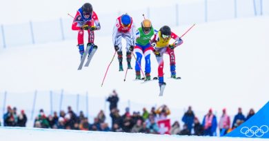 Four skiers race down a hill.