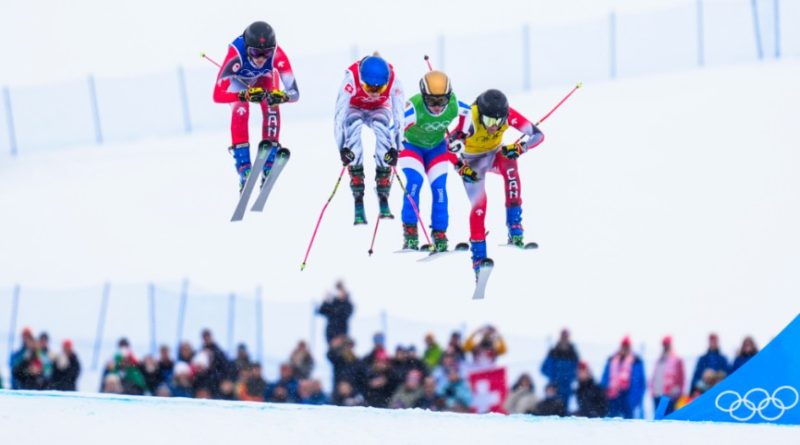 Four skiers race down a hill.