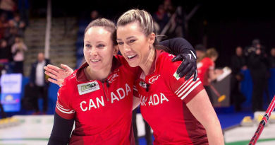 Two curlers embrace.