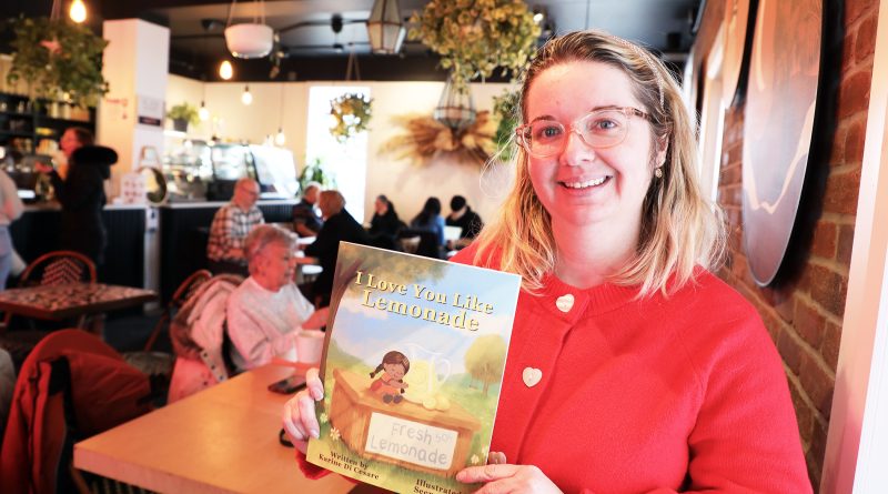 A photo of a woman holding a book.