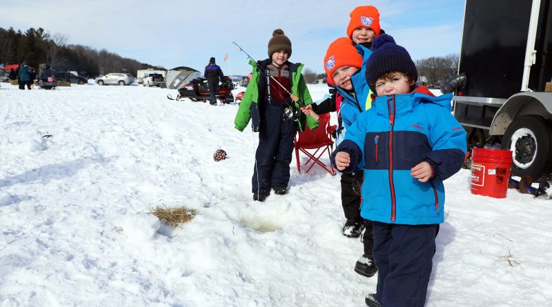 Some young kids ice fish.