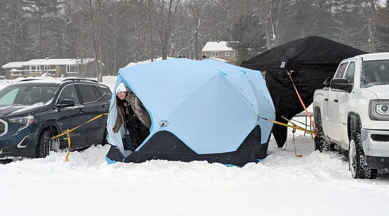 A woman peeks out of a tent.