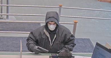 A bank video capture of a man holding a gun.