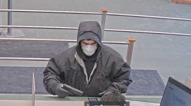 A bank video capture of a man holding a gun.