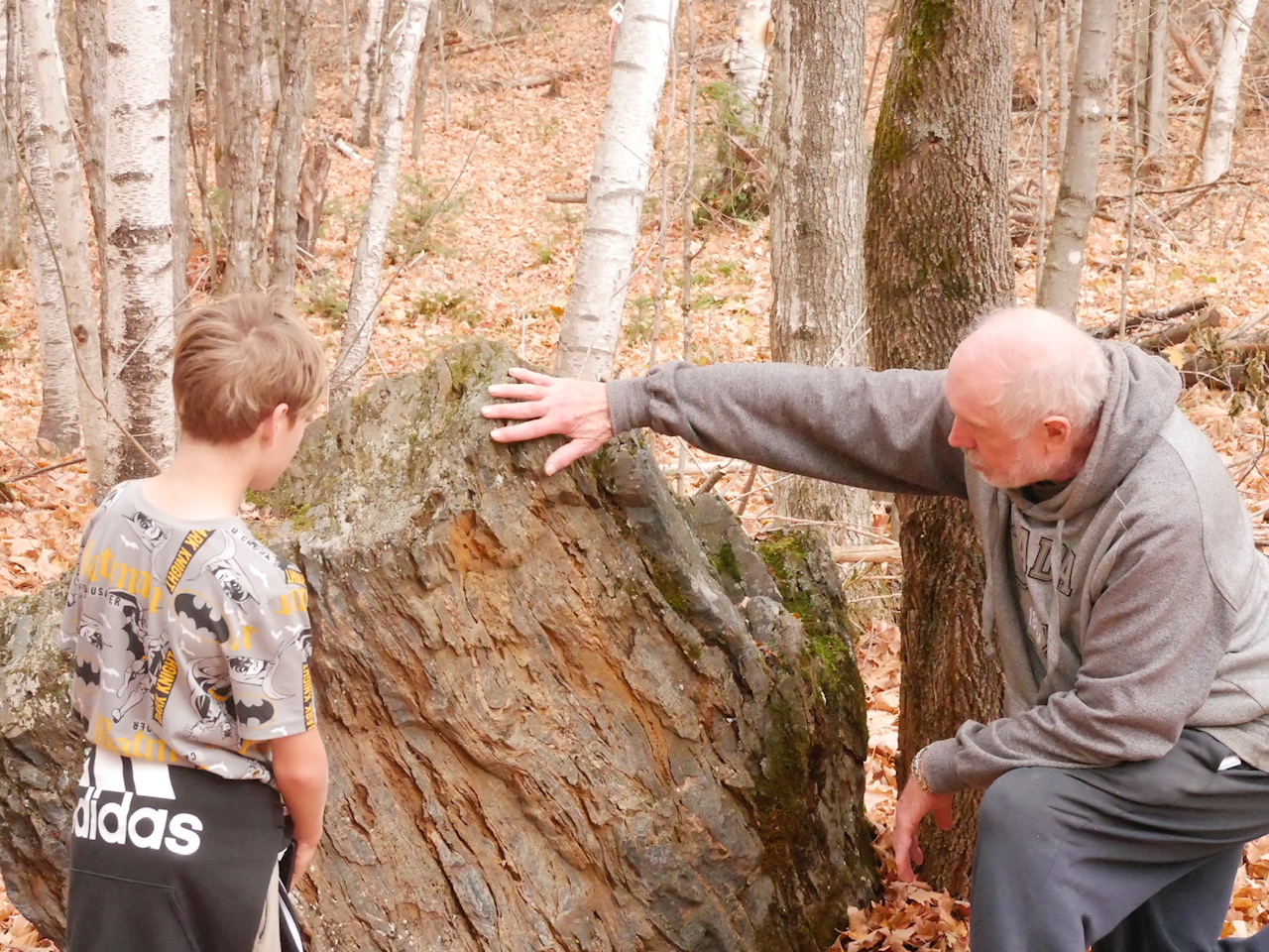 A nature guide explains rock formations to a youth.