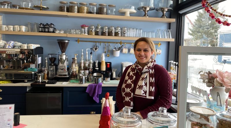 A woman poses in a cafe.