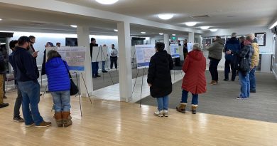 Carp intersection looks at roundabout A group of people look at posters.