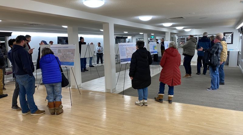 A group of people look at posters.