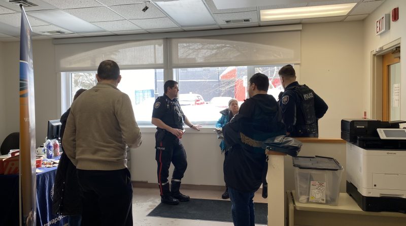 Cops chat with residents in a room.