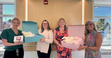 Nurses hold boxes filled with gifts.