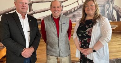 Three people pose for a photo.