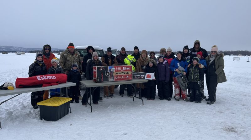 A group of people pose on the ice.