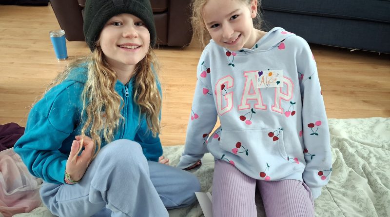 Two girls pose for a photo.