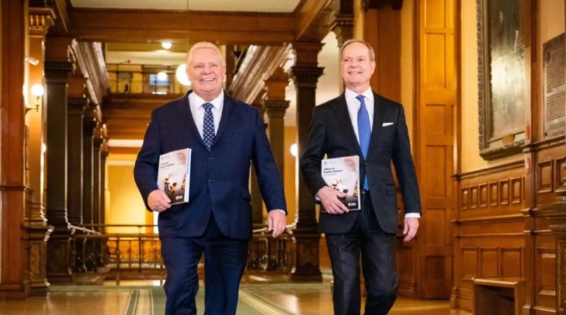 Two people walk down a hall.