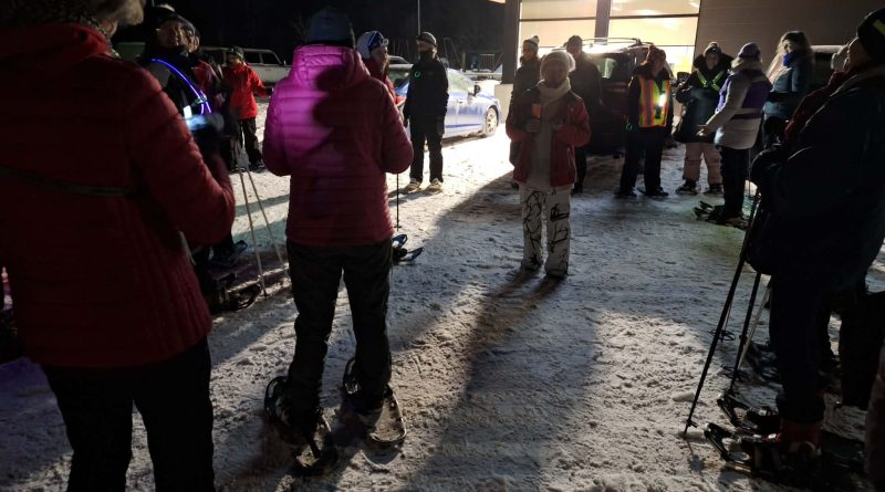 A group of snowshoers get ready for a hike.