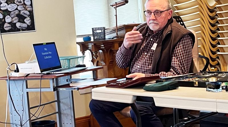 A man speaks at a table.