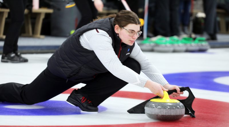 A curler delivers a stone.