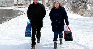 Two people walk in the snow.