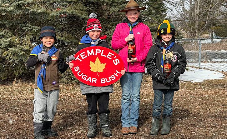 Four scouts pose with syrup.