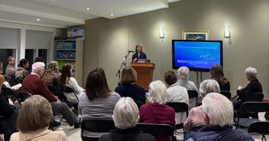 A speaker talks in a full room.