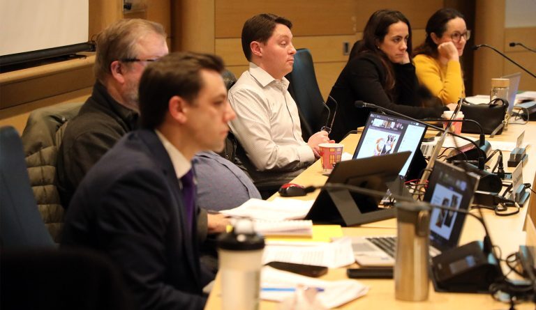 A committee listens during a meeting.