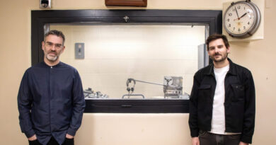 Two people pose in a radio studio.