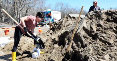 A woman fills a sandbag.