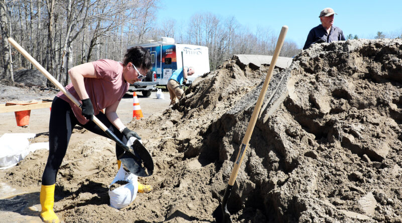 A woman fills a sandbag.