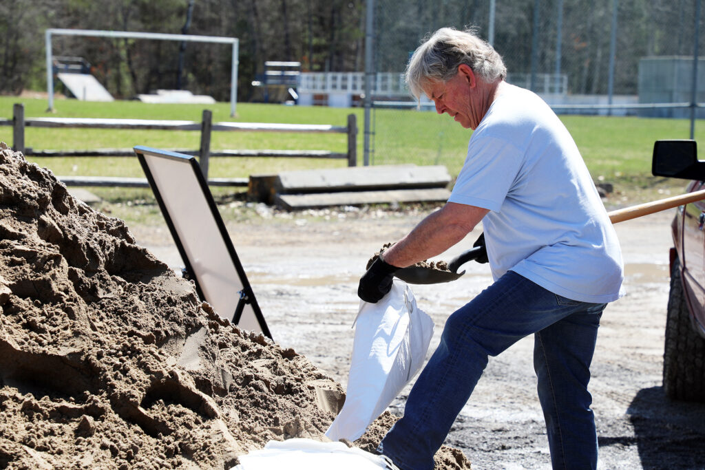 A photo of a man filling a sandbag.