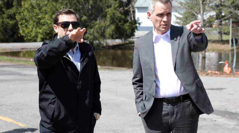 Two people talk on a road.