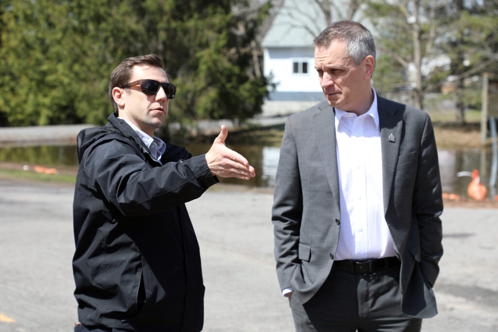 Two people talk on a road.