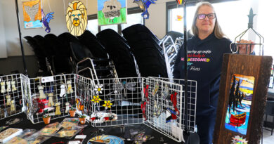 A woman poses with her artwork.