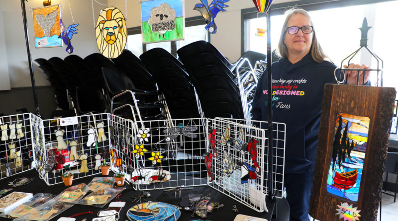 A woman poses with her artwork.