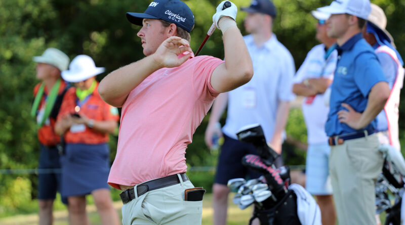 A golfer watches his shot.