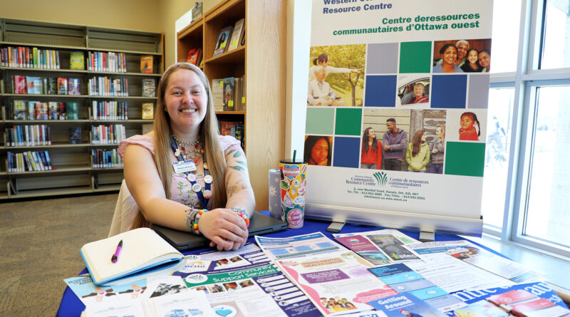 A woman sits at a desk.